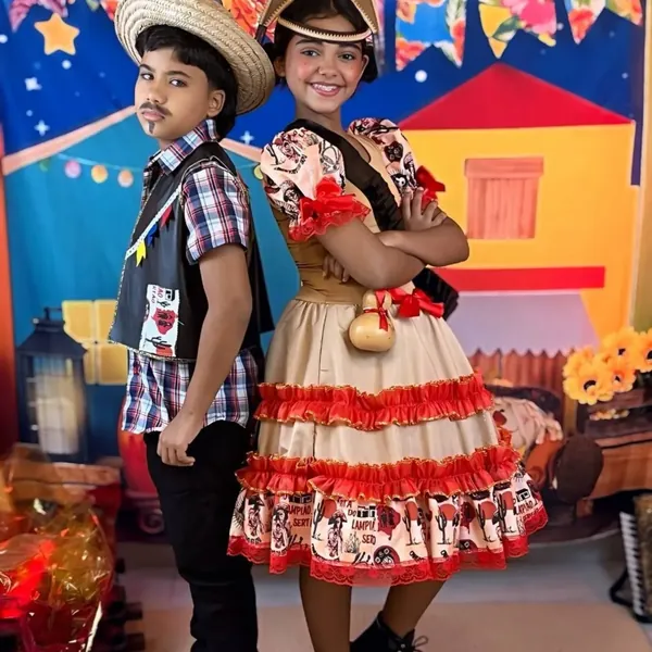 Menino e menina com trajes juninos completos da Casa do Bebê