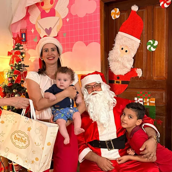 Proprietária da Casa do Bebê com famílias no evento de Natal da loja